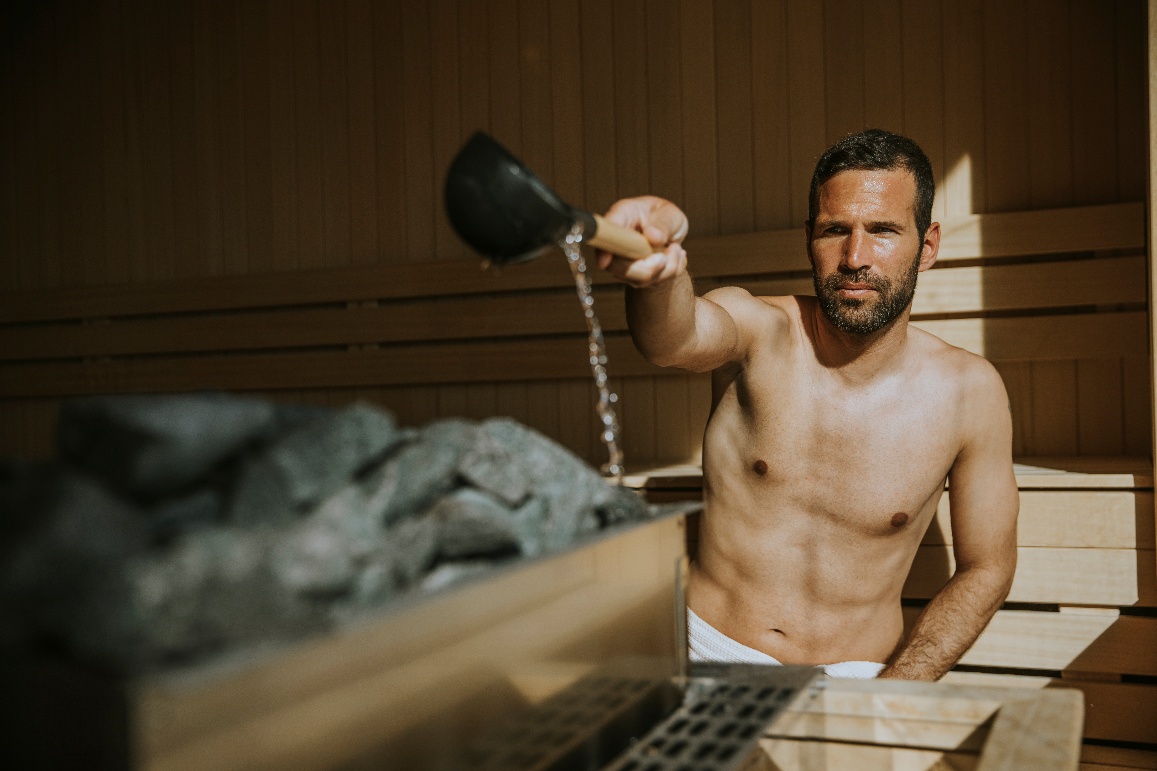 Ρίχνοντας νερό στις πέτρες της σάουνας